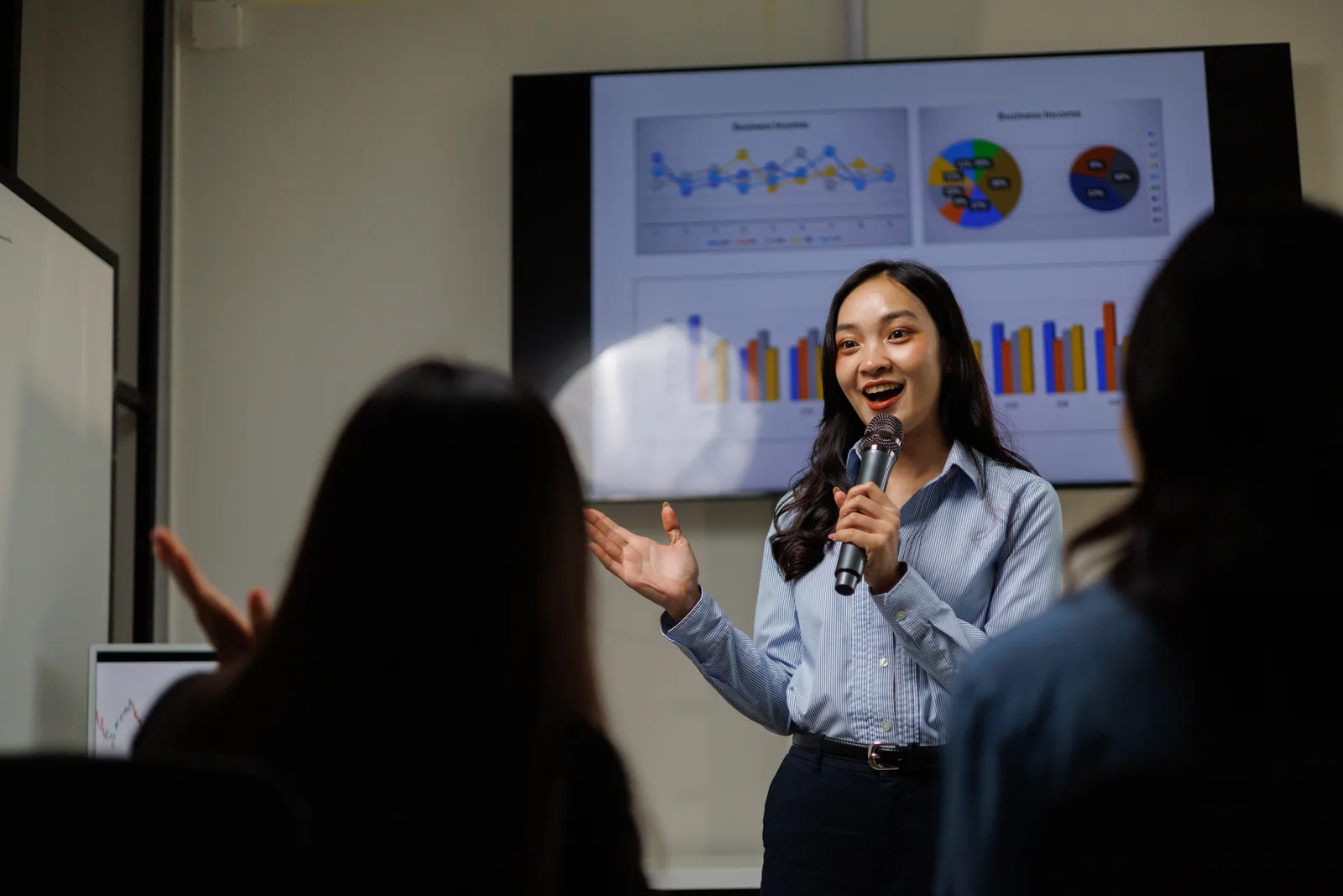 Illustrative photograph of a professional presenting business charts